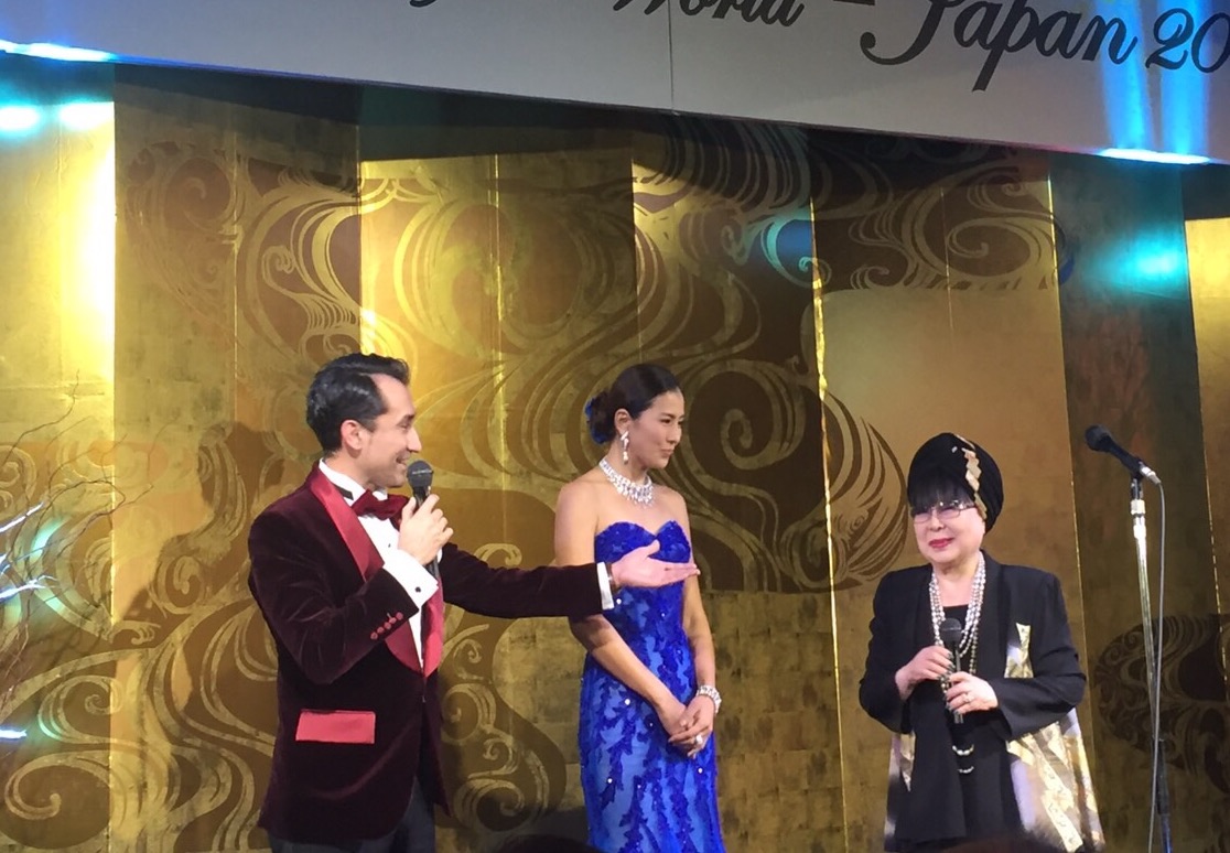Sena speaking on stage at an international cultural event